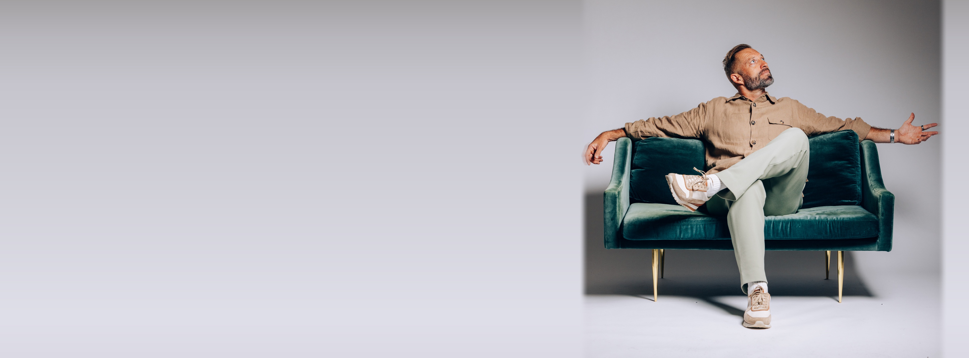 Seb Terry, keynote speaker, sitting on a teal couch